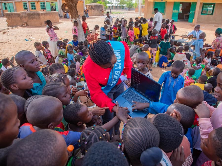 Faouzia Koussoubé showing a laptop to school children